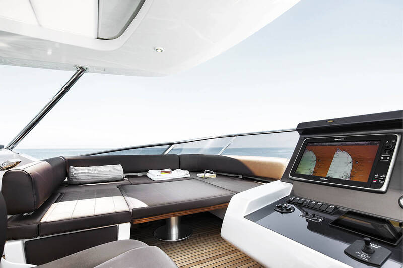Seating area next to helm station on fly convertible in sunbathing area